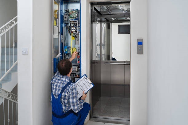 Technician Repairing Control Panel Of Broken Elevator elevator repair software 2